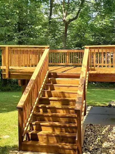 After: The same deck stairs after cleaning and staining, restored to warm brown wood