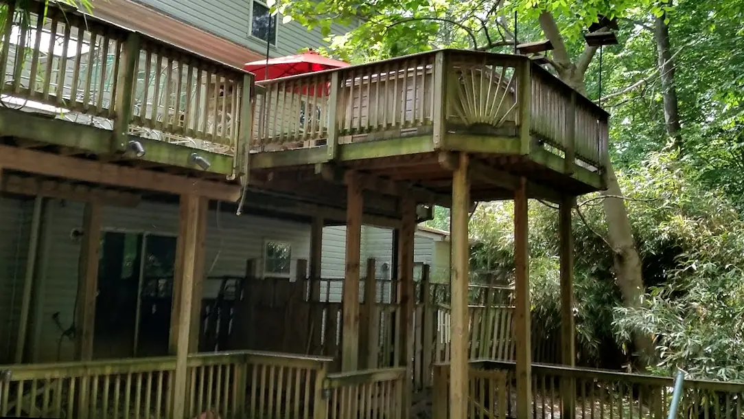 Before: Two-level wood deck under trees, gray and green with mildew and algae